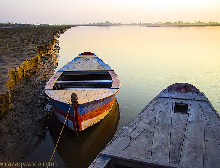 Parked Boats And Beauty Of Evening Light On A River Bank