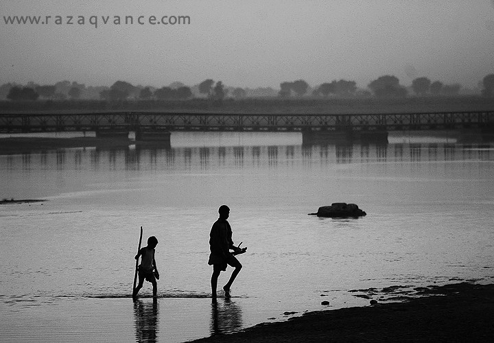 FATHER AND SON CROSSING THE RIVER RAVI IN A MISTY EVENING