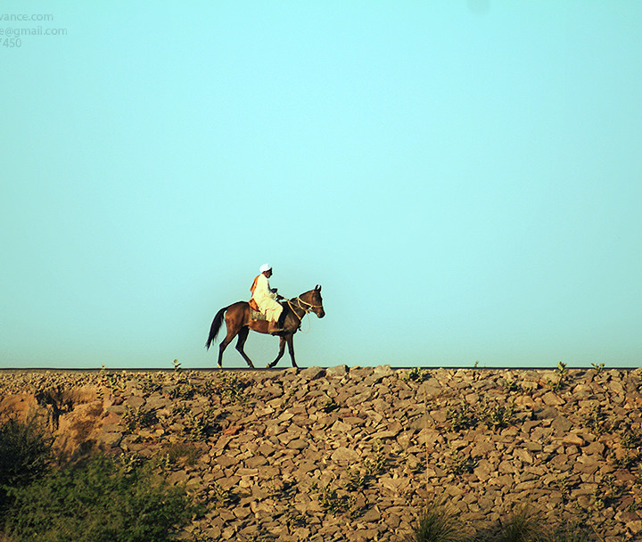 A Lone Horse Rider Is Travelling Over The Bank Of River Ravi